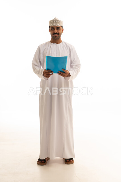 رجل عماني بالزي التقليدي يحمل ملف مستندات أزرق