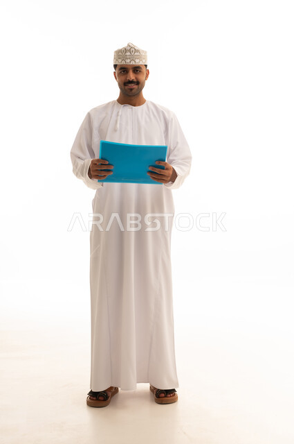 رجل عماني بالدشداشة يحمل ملفاً أزرق