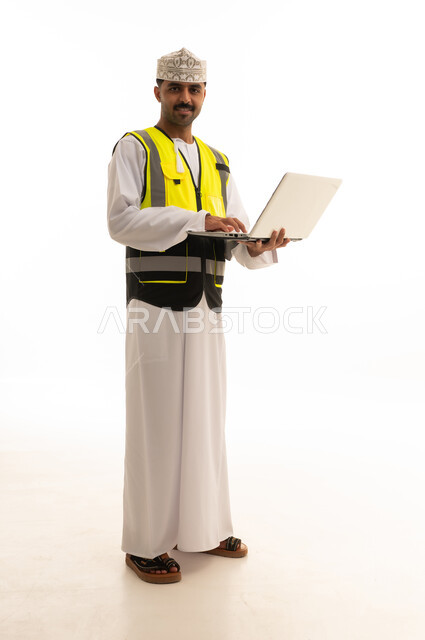 مهندس عماني بسترة السلامة يحمل جهاز محمول