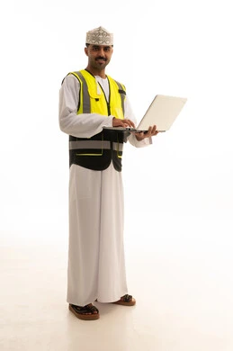 مهندس عماني بسترة السلامة يحمل جهاز محمول