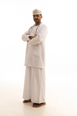 طبيب عماني بالزي الطبي أمام خلفية بيضاء