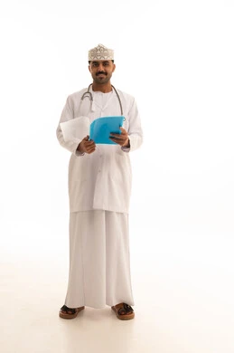 طبيب عماني يحمل ملف طبي على خلفية بيضاء