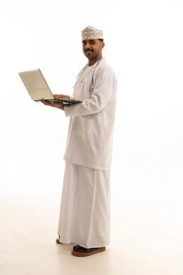 طبيب عماني مع جهاز كمبيوتر على خلفية بيضاء