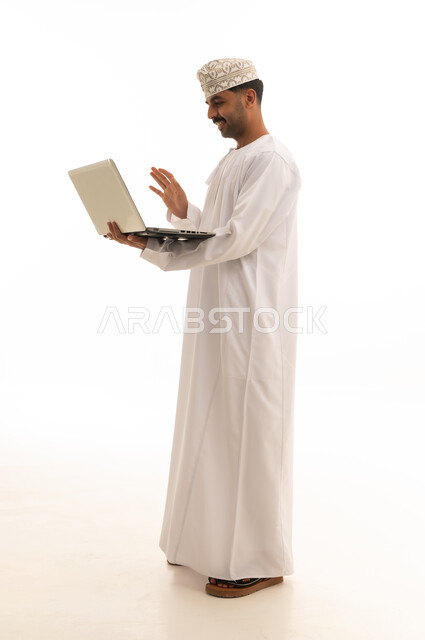 رجل عماني يستخدم الكمبيوتر المحمول خلفية بيضاء