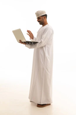 رجل عماني يستخدم الكمبيوتر المحمول خلفية بيضاء
