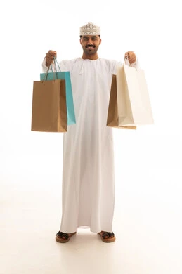 رجل عُماني يحمل أكياس تسوق بخلفية بيضاء