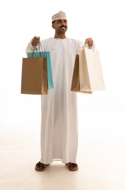 رجل عماني يحمل أكياس تسوق على خلفية بيضاء