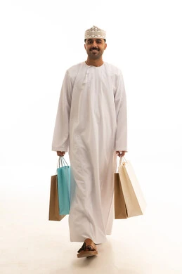 رجل عماني يحمل حقائب تسوق على خلفية بيضاء