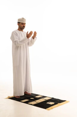 رجل عماني يصلي ويدعو على خلفية بيضاء