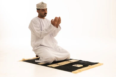 رجل عماني يصلي ويدعو على خلفية بيضاء