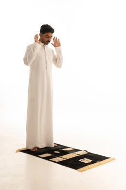 رجل سعودي يؤدي الصلاة على خلفية بيضاء