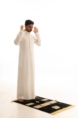 رجل سعودي يؤدي تكبيرة الإحرام على سجادة الصلاة