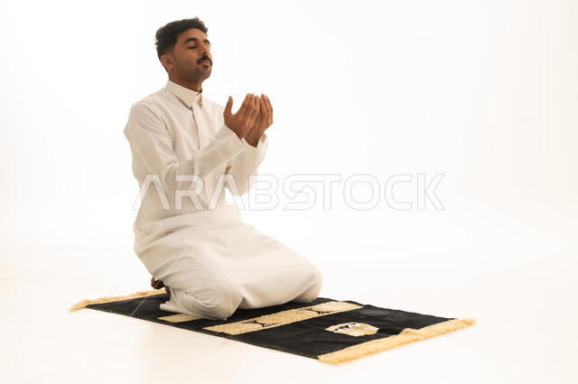 Saudi Man in Thobe Praying on Mat White Background