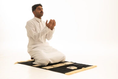 Saudi Man in Thobe Praying on Mat White Background
