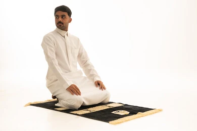 Saudi Man in White Thobe Praying on Mat