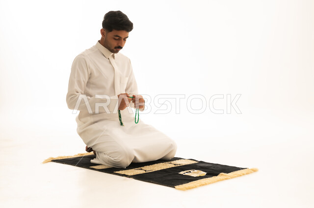 Saudi Man in White Thobe Praying with Beads