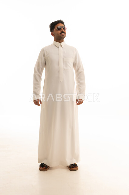رجل سعودي بالثوب التقليدي والنظارات الشمسية في الاستوديو