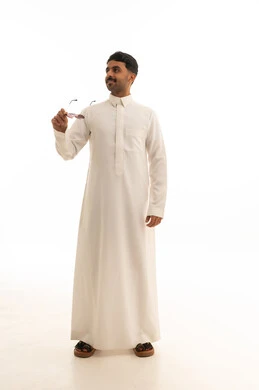رجل سعودي بالثوب الأبيض يحمل نظارة شمسية خلفية بيضاء