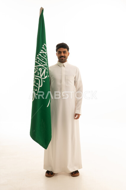 رجل سعودي يحمل علم السعودية في استوديو