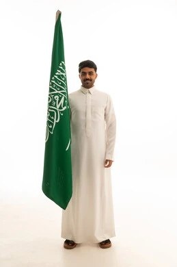 رجل سعودي يحمل علم السعودية في استوديو