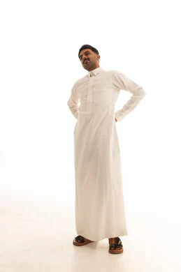 رجل سعودي بالثوب الأبيض التقليدي على خلفية بيضاء