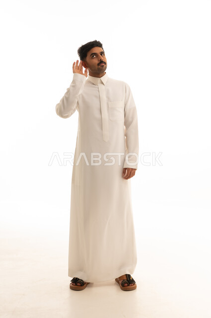 رجل سعودي بالثوب الأبيض يستمع بخلفية بيضاء