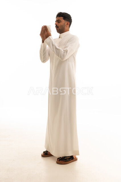 Saudi Man Sneezing into Tissue in White Thobe