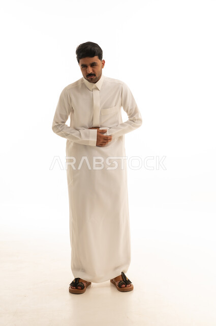 رجل سعودي يرتدي الثوب التقليدي يعاني من ألم في المعدة
