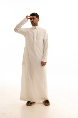 رجل سعودي بالثوب الأبيض ينظر للأفق خلفية بيضاء