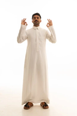 رجل سعودي بالثوب الأبيض يمارس التأمل خلفية بيضاء
