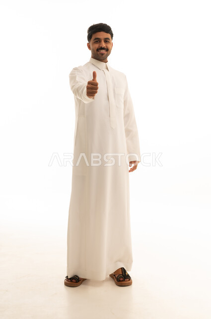 رجل سعودي بالثوب التقليدي يرفع علامة الإبهام