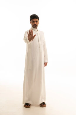 رجل سعودي بالثوب التقليدي يقوم بإشارة التوقف