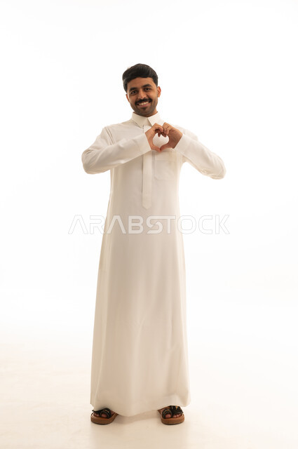 رجل سعودي بالثوب التقليدي يصنع علامة قلب