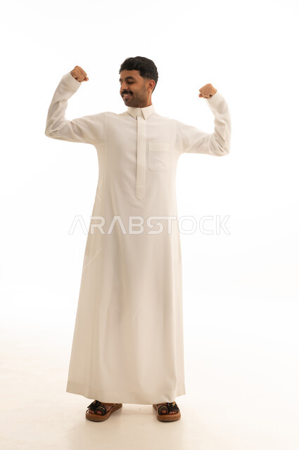 رجل سعودي بالثوب التقليدي يستعرض عضلاته