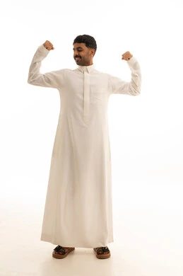 رجل سعودي بالثوب التقليدي يستعرض عضلاته