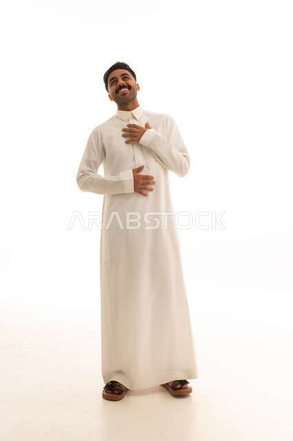 رجل سعودي مبتسم يرتدي الثوب في استوديو