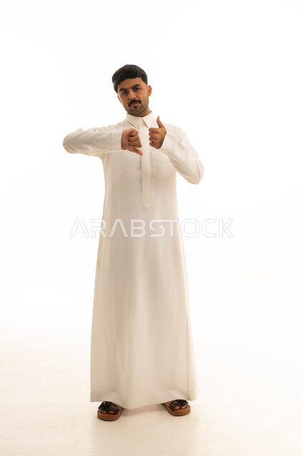 رجل سعودي بالثوب يرفع ويخفض إبهامه