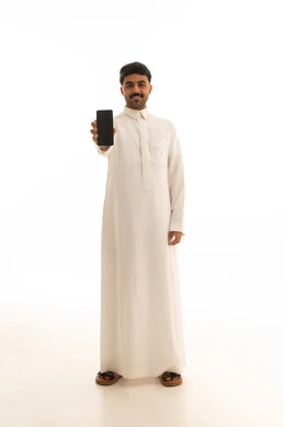 رجل سعودي بالثوب التقليدي يحمل هاتف ذكي