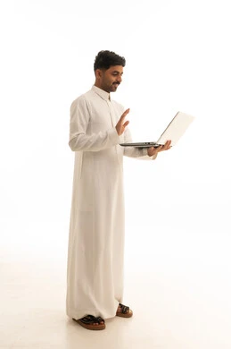 رجل سعودي مع لابتوب يلوح في مكالمة فيديو