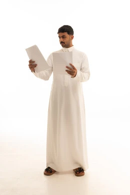 رجل سعودي يرتدي الثوب التقليدي يقرأ مستندات