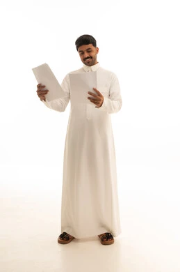 رجل سعودي يراجع مستندات ورقية بخلفية بيضاء