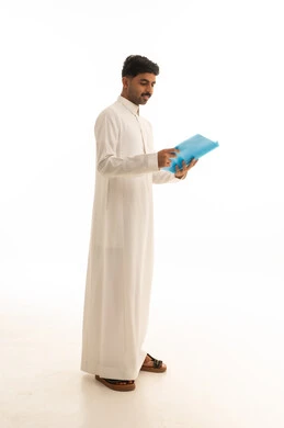 رجل سعودي بالثوب الأبيض يحمل ملفاً أزرق لقطة كاملة