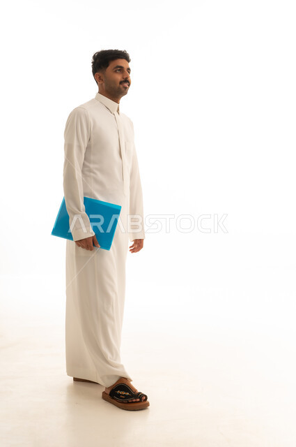 رجل سعودي بالثوب الأبيض يحمل ملفاً أزرق