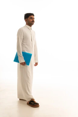 رجل سعودي بالثوب الأبيض يحمل ملفاً أزرق