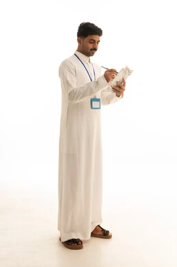 موظف سعودي بالثوب الأبيض يكتب على لوحة ملاحظات