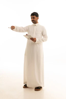 رجل سعودي يمسك لوحة ورقية ويشير بخلفية بيضاء