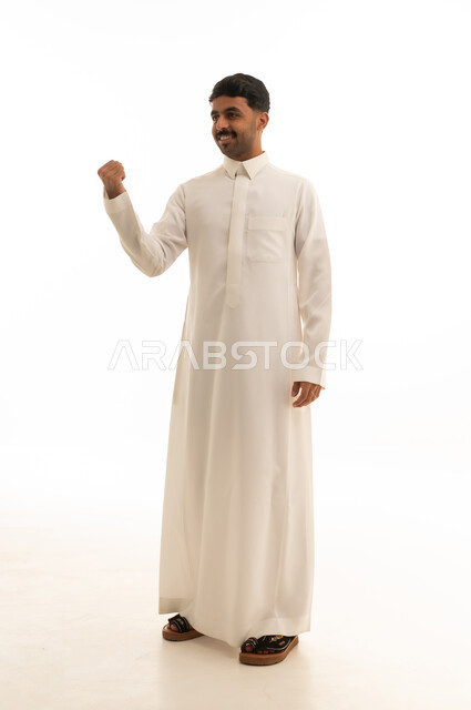 رجل سعودي بالثوب الأبيض مع إشارة النصر