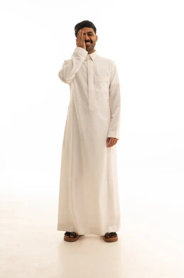 رجل سعودي مبتسم بالثوب الأبيض على خلفية بيضاء
