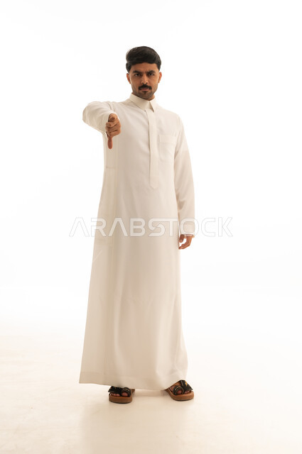 رجل سعودي بالثوب الأبيض يشير بالإبهام للأسفل