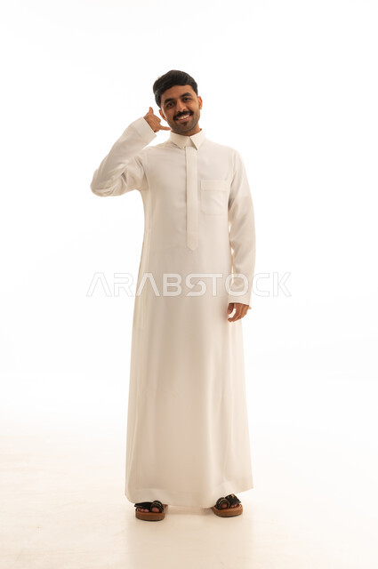 رجل سعودي بالثوب الأبيض يشير بعلامة الاتصال باليد